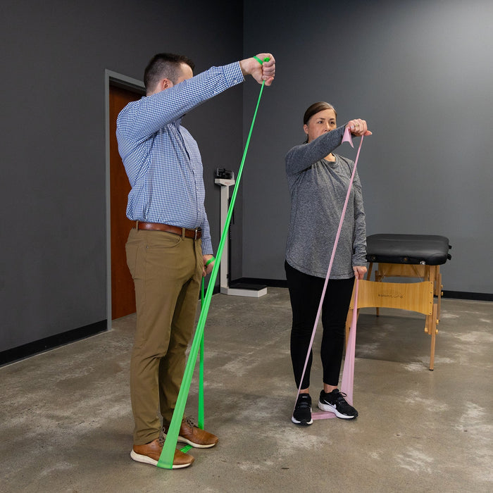 Two people using resistance bands in a therapy or exercise setting.