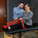 Physiotherapist assisting a patient with resistance bands on a therapy table.