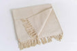 Beige woven yoga mat with fringes on a white background
