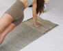 Person practicing yoga on a yoga mat with a neutral background
