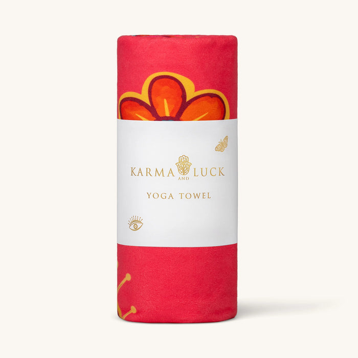 Roll of Karma Luck yoga towel with red and orange design on a white background
