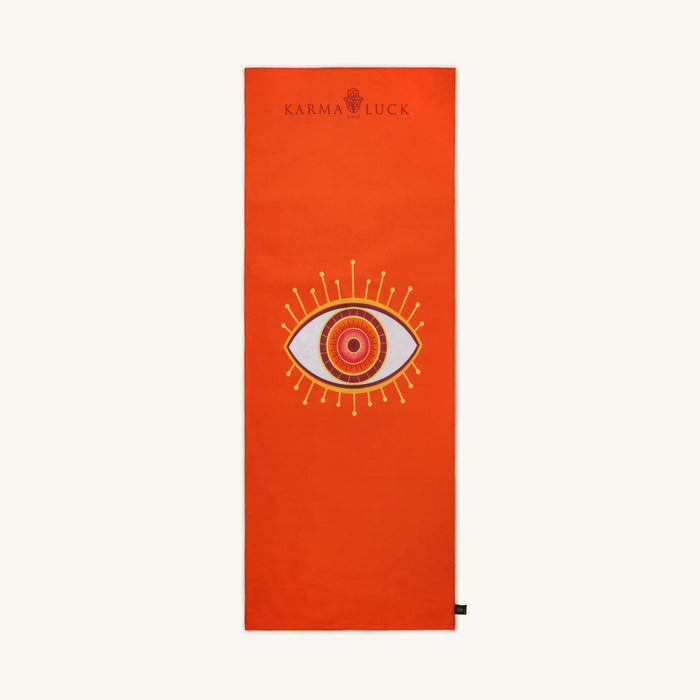 Orange yoga mat with eye design and Karma Luck logo on a white background
