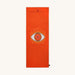 Orange yoga mat with eye design and Karma Luck logo on a white background