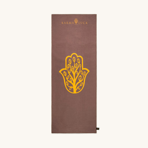 Brown yoga towel with yellow Hamsa hand design and 'Karma Luck' branding on a white background