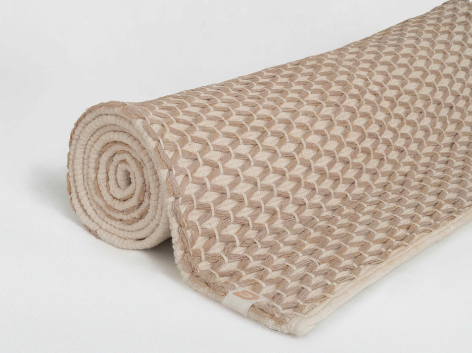 Rolled-up beige textured yoga mat on a white background