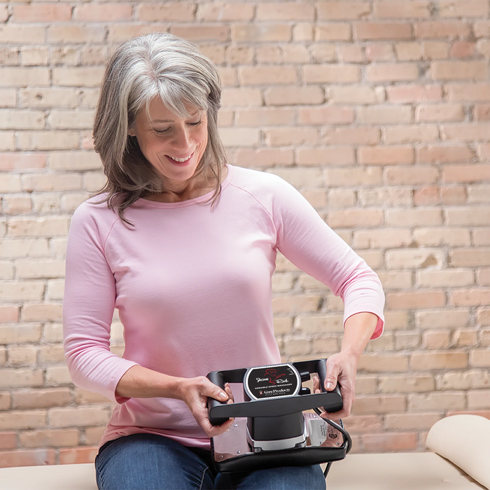 Woman using a handheld device against a brick wall background