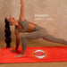 Woman in a yoga pose on a red mat with 'Balance IN EVERY POSE' text